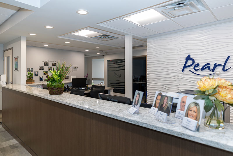 Interior front lobby and reception desk of Pearl Dental Associates.
