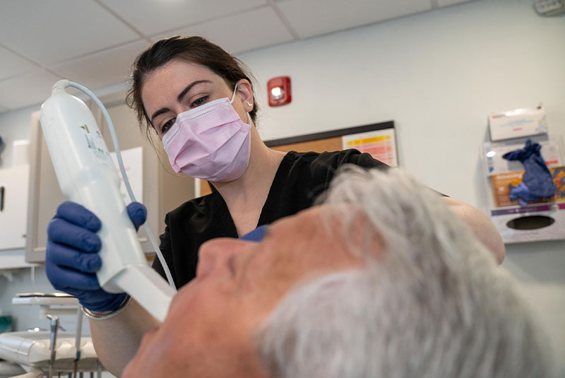 Dr. Caron scanning patient's teeth